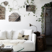 Vintage wall mirrors, trailling greenery, white linen sofa and logs used as side tables at The Chapel, Byron Beach Abodes