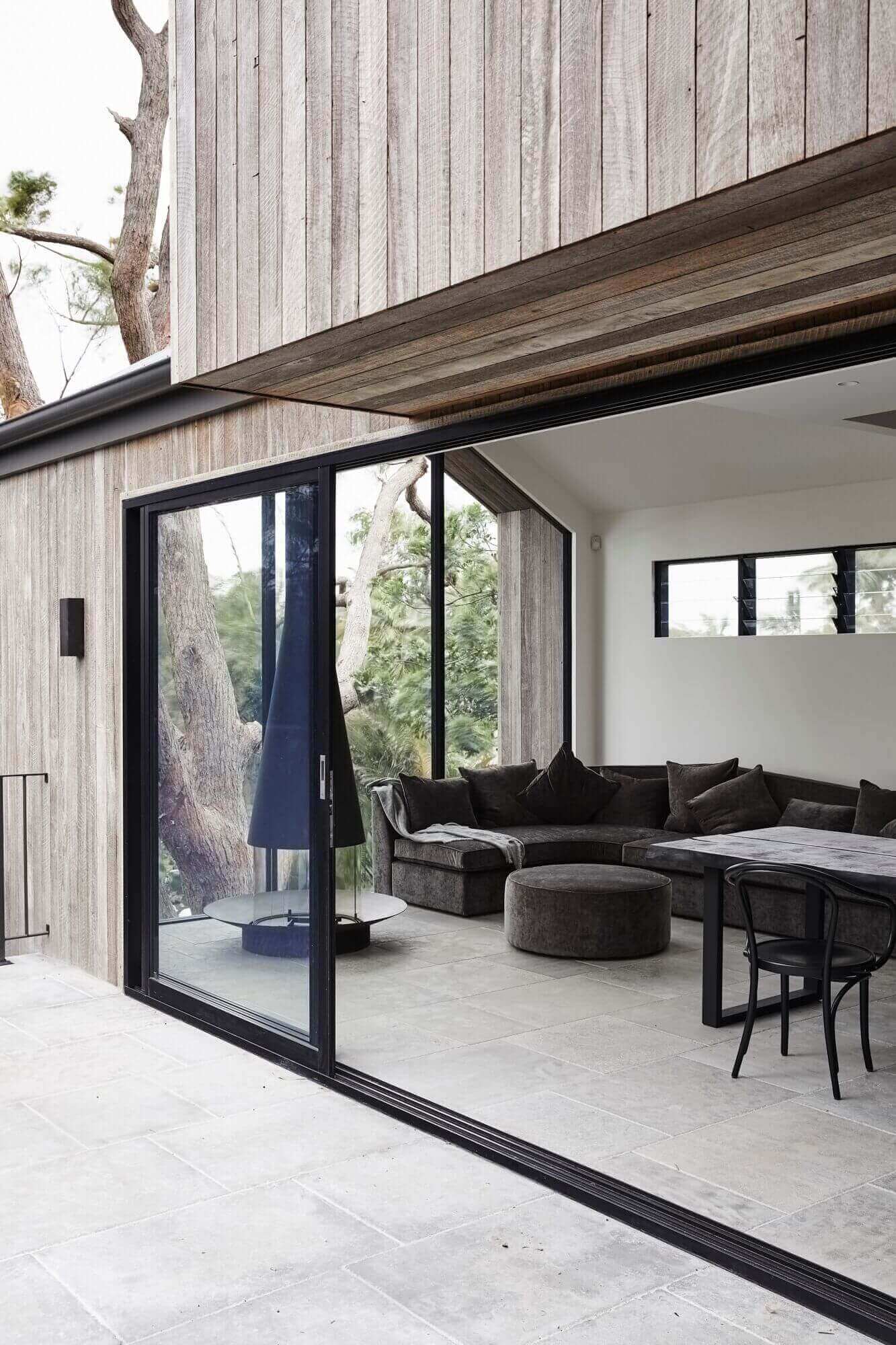 Lounge room at The Cabin, Byron Beach Abodes with Oblica fireplace, custom lounge and limestone flooring