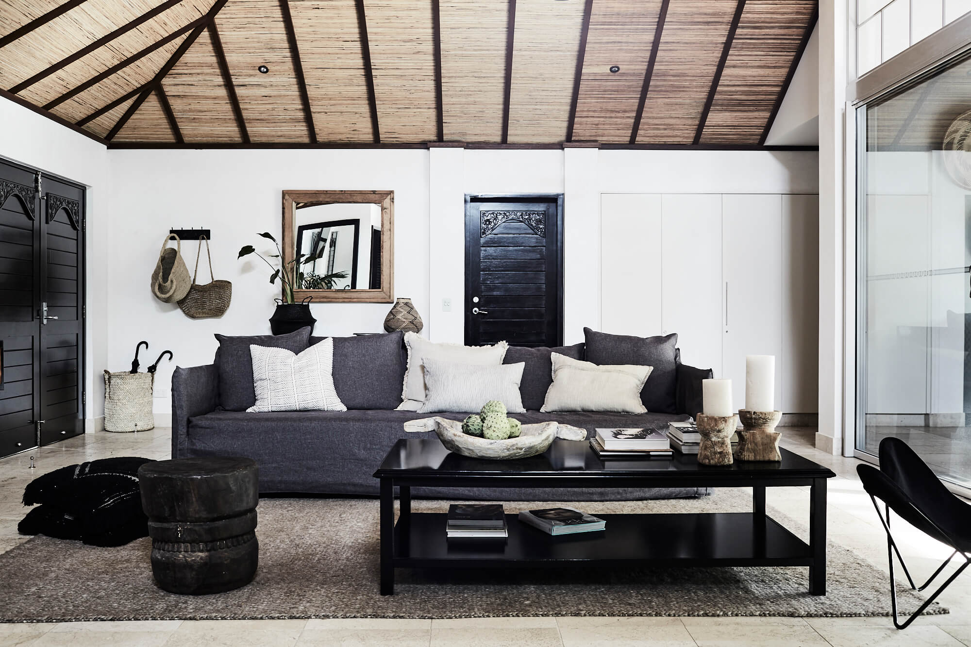 Luxury open lounge room with linen sofa, lots of cushions, textured rug, thatched vaulted ceiling at The Villas of Byron