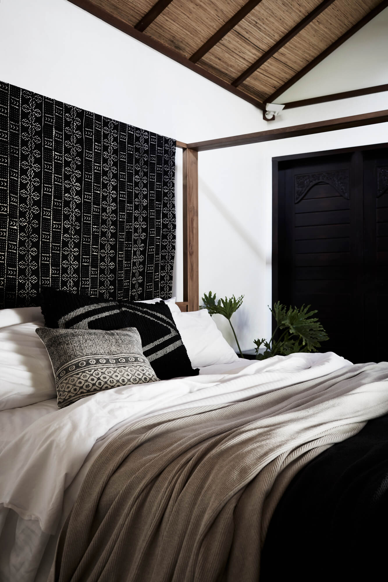 Comfortable bed at The Villas of Byron with linen throws and textured cushions