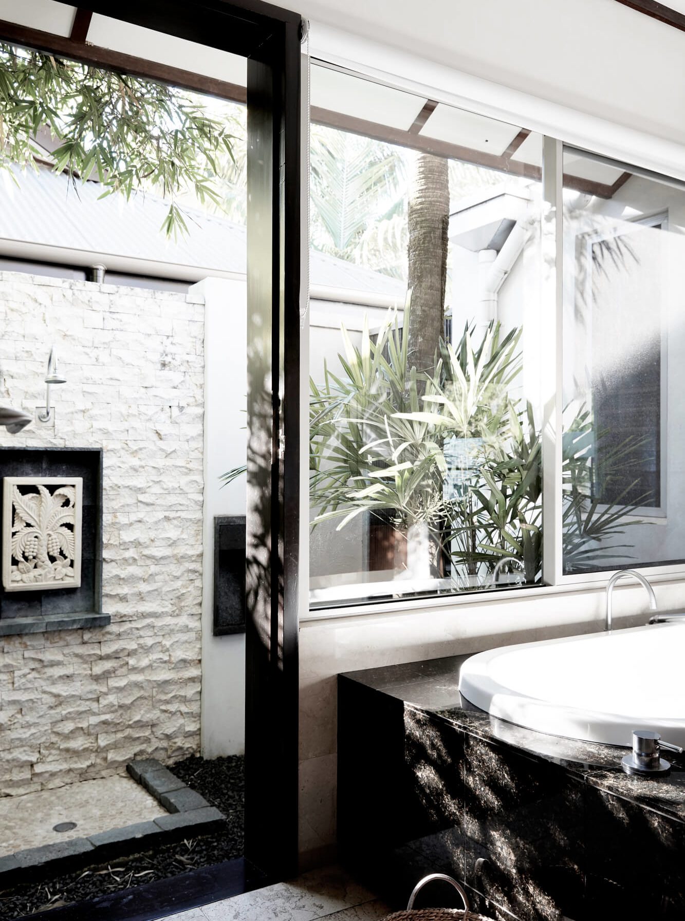 The Villas of Byron master ensuite with bathtub looking out to the private courtyard with outdoor shower and tropical planting