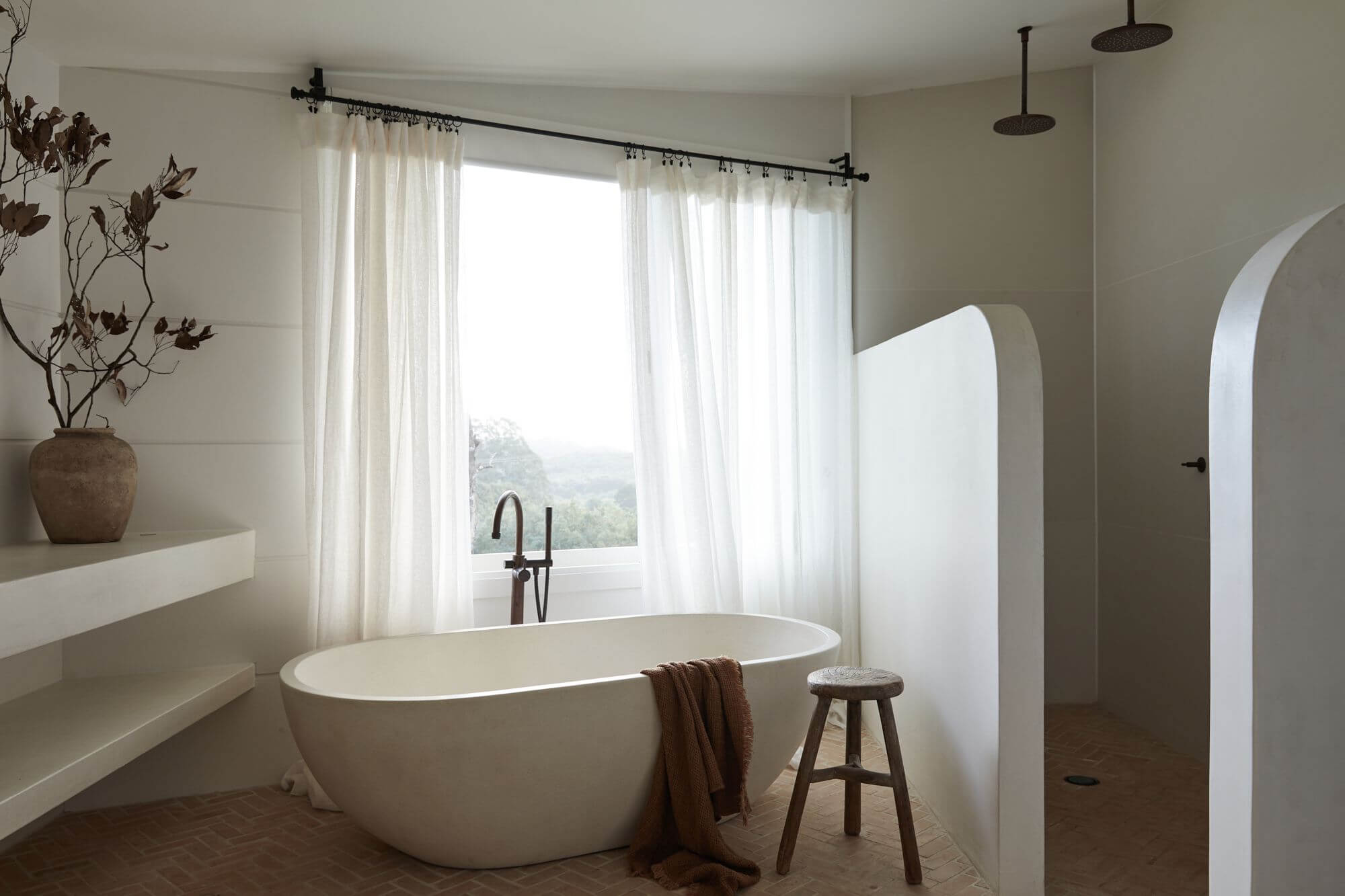 Le Viti Barn Newrybar: Rustic style ensuite with terracotta herringbone tiles, linen curtains, a curved shower wall and custom open-shelves on the vanity