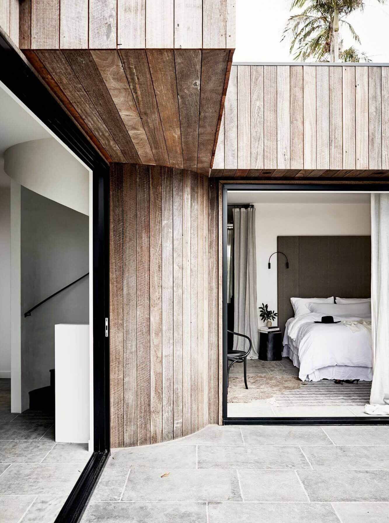 Curved, recycled Jarrah clad wall at The Cabin, Byron Beach Abodes