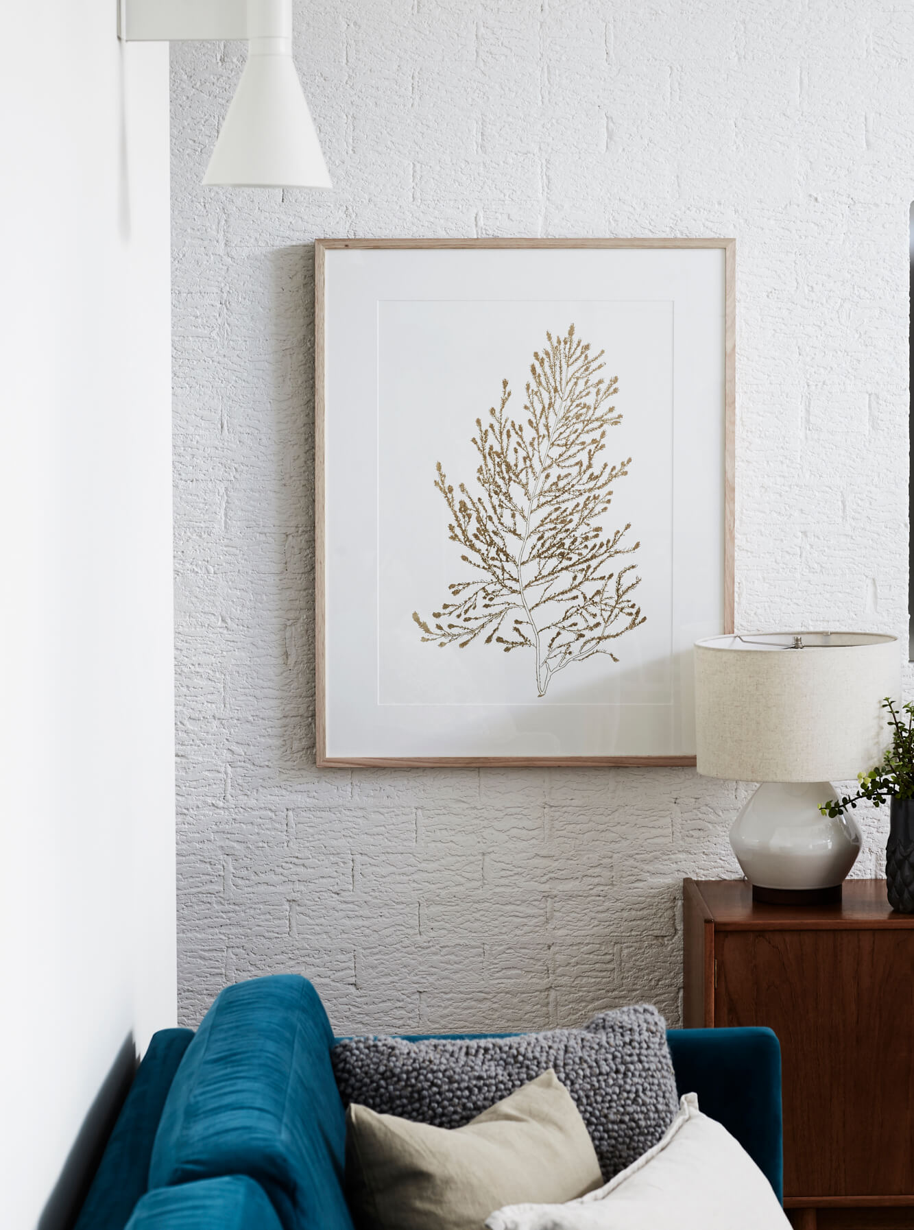 Design details at The Chalet, Byron Beach Abodes including framed print, painted brick wall, and custom velvet lounge