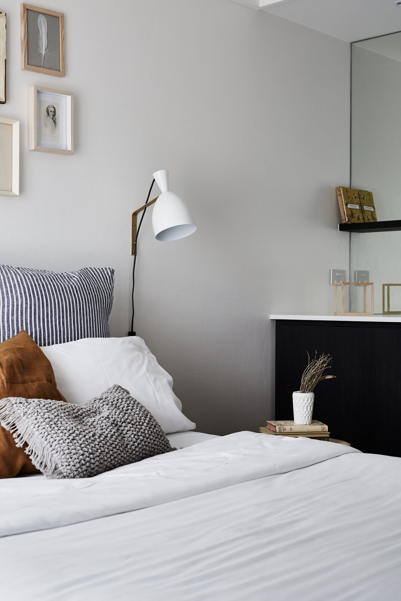 Comfortable bed at the Bower Suites, The Bower Byron Bay hotel with linens and cushions in white, stripes and earthy tones