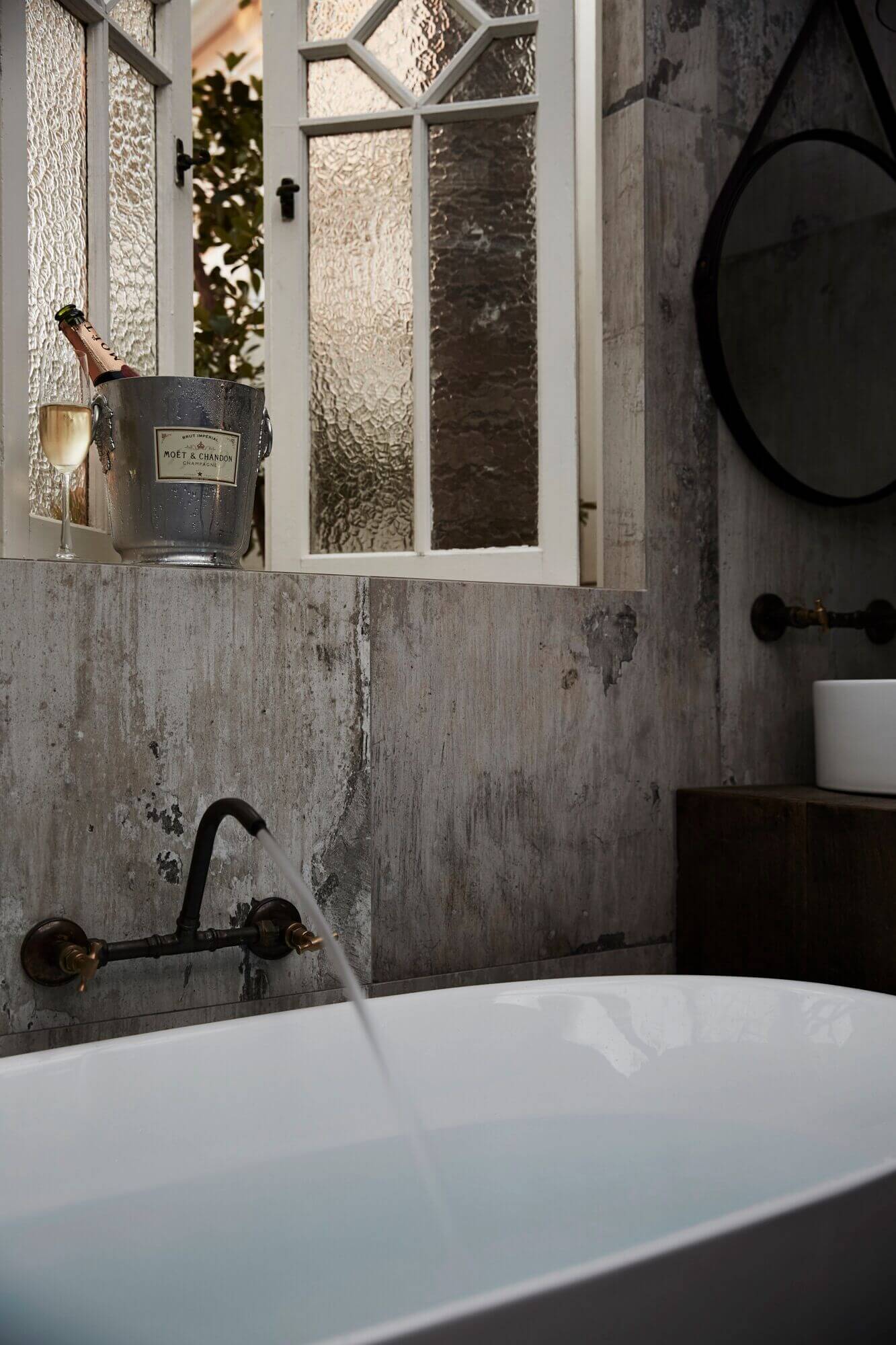 Moet champagne in ice bucket beside the running bath at the Bower Barn, The Bower Byron Bay hotel