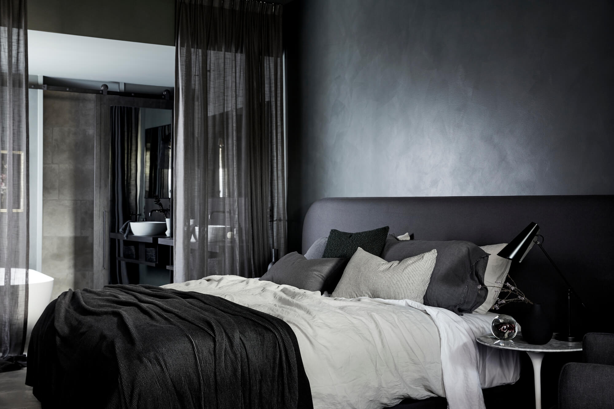 Open plan bedroom and ensuite separated by a full heigh linen curtain at the Deluxe King Rooms at The Bower Byron Bay hotel