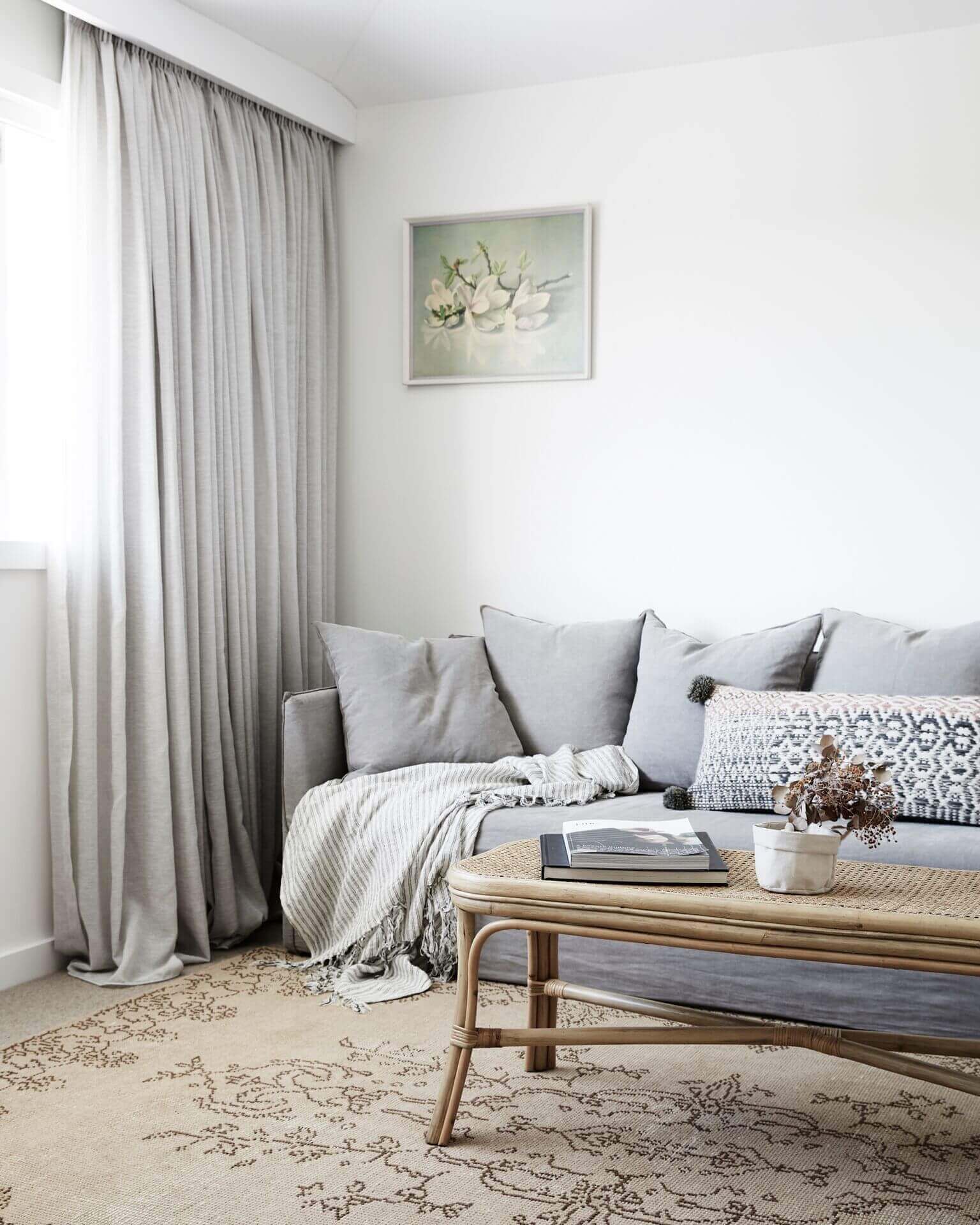 Master retreat sitting area at Magnolia House, Byron Beach Abodes with plush linen lounge, vintage rug and artwork, and flowy linen curtains